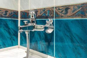 water tap sink with faucet in expensive loft bathroom. detail of a corner shower cabin with wall mount shower attachment photo