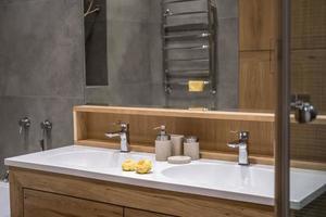 details of corner with water tap sink with faucet with soap and shampoo dispensers in expensive bathroom in rustic eco style photo