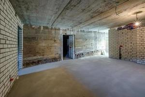 Empty basement room with minimal preparatory repairs. interior with white brick walls photo