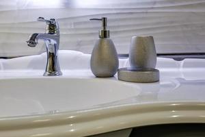 Ceramic Water tap sink with faucet with soap and shampoo dispensers in expensive loft bathroom or kitchen photo