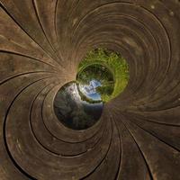 Inversion of little planet transformation of spherical panorama 360 degrees. Spherical abstract aerial view on field with awesome beautiful clouds. Curvature of space. photo