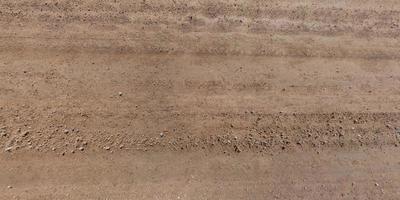 view from above on car tire tracks on texture of gravel road photo