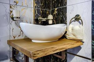 water tap sink with faucet in expensive loft bathroom. detail of a corner shower cabin with wall mount shower attachment photo