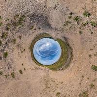 inversión de la transformación del pequeño planeta azul del panorama esférico de 360 grados. vista aérea abstracta esférica en el campo con impresionantes nubes hermosas. curvatura del espacio. foto