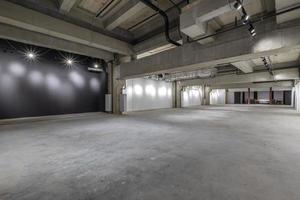 empty interior of large concrete room as warehouse or hangar with spotlights photo