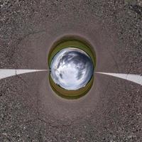 Inversion of blue little planet transformation of spherical panorama 360 degrees. Spherical abstract aerial view on road with awesome beautiful clouds. Curvature of space. photo