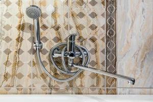 water tap sink with faucet in expensive loft bathroom. detail of a corner shower cabin with wall mount shower attachment photo