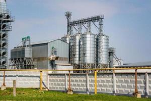 ascensor de granero moderno. silos de plata en la planta de procesamiento y fabricación de productos agrícolas para el procesamiento, secado, limpieza y almacenamiento de productos agrícolas, harina, cereales y granos. línea de limpieza de semillas foto