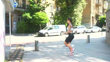 Fit young woman jumps rope on a concrete sidewalk video