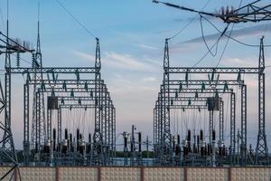 Silhouette of the high voltage electric pylon towers on the background of beautiful evening clouds photo