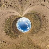 blue sky ball in middle of swirling asphalt road. Inversion of tiny planet transformation of spherical panorama 360 degrees. Spherical abstract view. Curvature of space. photo