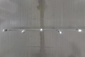 cassette suspended ceiling with square halogen spots lamps and drywall construction in empty room in apartment or house. Stretch ceiling white and complex shape. Looking up view photo