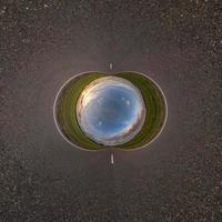 Inversion of blue little planet transformation of spherical panorama 360 degrees. Spherical abstract aerial view on road with awesome beautiful clouds. Curvature of space. photo