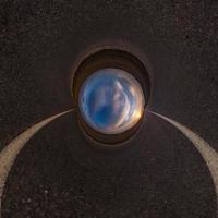 Inversion of blue little planet transformation of spherical panorama 360 degrees. Spherical abstract aerial view on road with awesome beautiful clouds. Curvature of space. photo