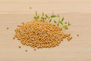 Mustard seeds on wooden background photo