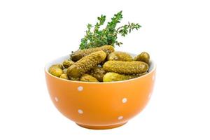 Marinated cucumbers in a bowl on white background photo