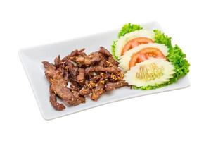 Fried pork thai style on the plate and white background photo