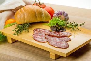 Salami on wooden plate photo