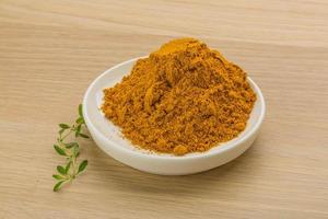 Curry powder on wooden background photo