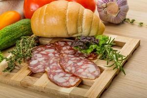 Salami on wooden plate photo