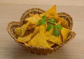 Nachos in a basket on wooden background photo