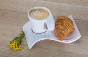 Coffee with croissant on the board photo