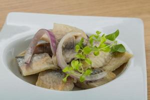 Sliced herring on the plate and wooden background photo