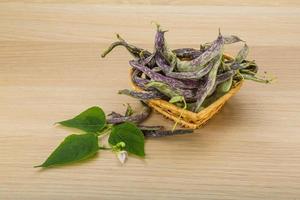 Beans with leaf in a basket on wooden background photo