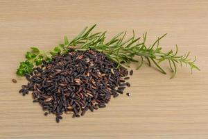 Wild black and brown rice on wooden background photo