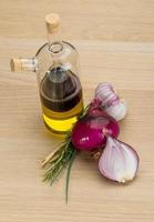 Oil, vinegar with onion on wooden background photo