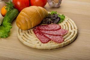 Salami on wooden plate photo