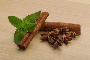 palitos de canela y anís estrellado sobre fondo de madera foto