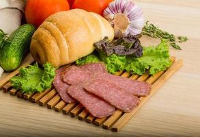 Salami on wooden plate photo