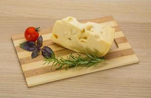 Maasdam cheese on wooden background photo