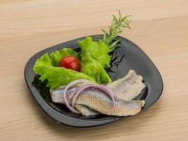 Herring fillet on the plate and wooden background photo