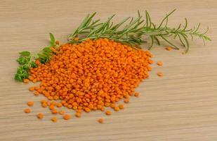 Raw red lentils on wooden background photo