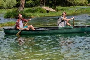 friends are canoeing in a wild river photo
