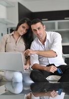 joyful couple relax and work on laptop computer at modern home photo