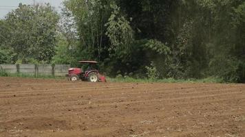 un granjero ara su campo seco en verano