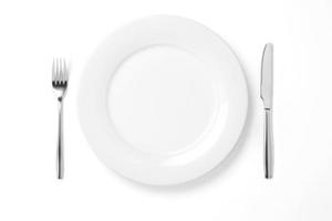 Empty plate with knife and fork isolated on a white background. photo