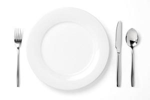 Empty plate with spoon, knife and fork isolated on a white photo