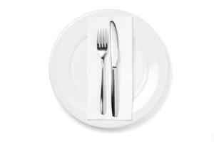 Empty plate with knife and fork isolated on a white background. photo