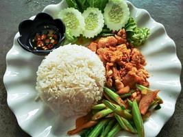 Cooked rice with fried chicken and vegetables photo