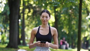 garota de ioga no parque usa telefone video