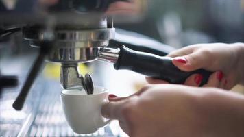 cerrar las manos del barista sirviendo chupitos de espresso en un vaso de chupito de cerámica blanca video