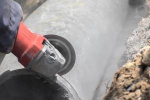 fontaneros cortando tuberías de agua de hormigón foto