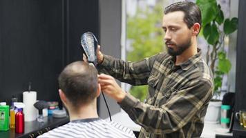 peluquero peina el cabello de un cliente masculino con secador y peine video