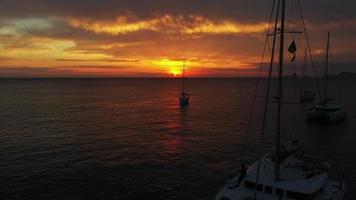 vlieg over- oceaan visie van jachten in oranje en geel zonsondergang licht video