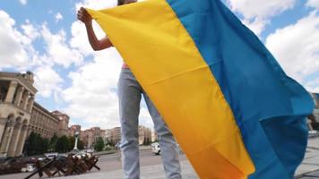 jovem segura e acena a bandeira da ucrânia no centro de kyiv video