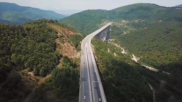 Aerial view of road and bridge in green mountains video